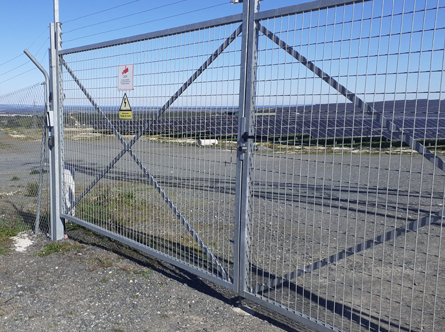Großes Doppeltor mit Metallgitter am Solarpark, ausgestattet mit elektronischer Schließtechnik